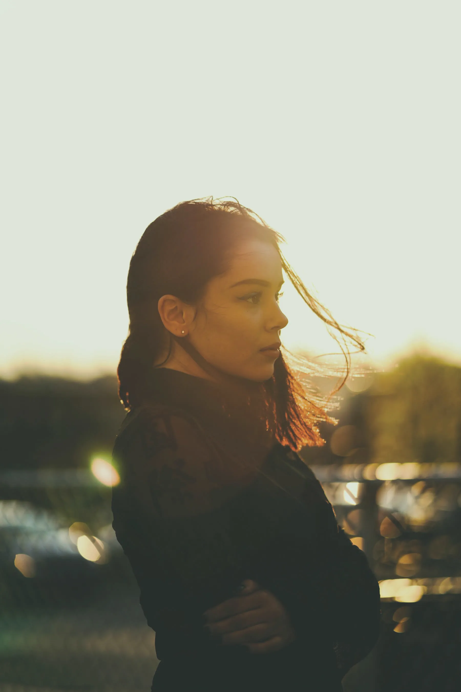 A portrait at sunset against a grey metal fence
