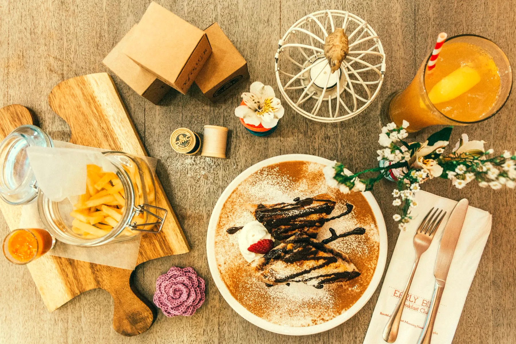 An overhead flat lay of breakfast plates on a wooden table